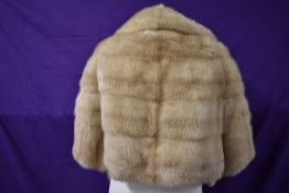 A blonde mink shrug with sleeves/jacket having F.M.R monogram to lining.