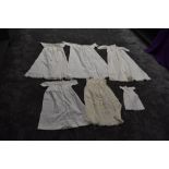 A selection of antique items of baby clothing including one long gown with cut work and