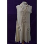 A cream silk 1920s day dress having button front and dropped waist with embroidered floral details