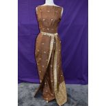 A vintage full length 1950s dress having gold thread motifs on a copper coloured silk or silk