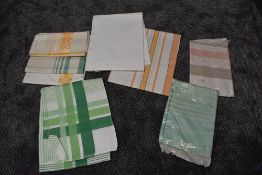 A variety vintage of table cloths including damask, some still in packaging.