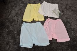 Four pairs of vintage nylon knickers in pastel shades, all appear unworn.