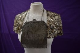 An early 20tch century chain mail bag with floral embossed handle and a tulle caplet having