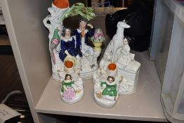 A selection of Staffordshire flatback figures including girl with dogs and spill vase pair