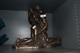 A modern resin cast sculpture of two lovers embracing by Heredities