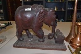 A large carved Indian styled wooden elephant on plinth.