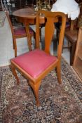 A set of four early 20th Century stained frame dining chairs and an oak rail back dining chair