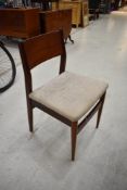 A set of four vintage teak or similar dining chairs having ply backs and upholstered seats