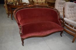 A late Victorian settee having scroll frame and later red dralon upholstery, width approx. 157cm