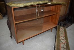 A vintage teak or sapele bookcase, with sliding glass doors