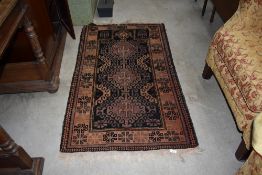 A traditional Persian rug in the Kazak style, faded black and purple ground, approx. 140 x 82cm