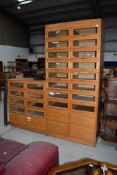 Two sets of vintage shop/merchants drawers, having glass fronts, with deeper lower drawers, taller