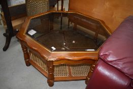 A modern glass top coffee table of octagonal form, shaped top and canework undertier, width