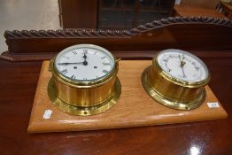 A brass marine style clock mounted on golden oak and a similar barometer, board size approx. 54 x