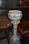 A late 19th/early 20th Century ceramic jardiniere and stand, unfortunately cracked throughout