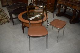 A pair of vintage dining chairs having amber perspex rail back on chrome frames with vinyl seats,