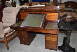 An early 20th Century mahogany cylinder roll top desk/ having fitted interior including raising