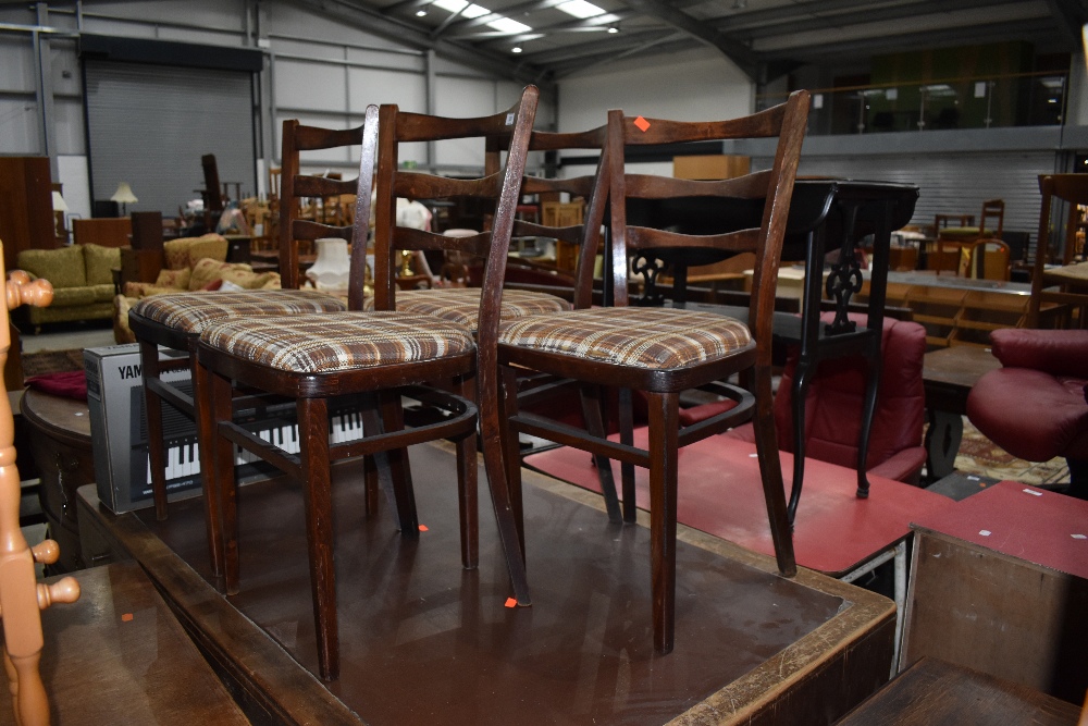 A set of four mid century bent wood dining chairs with arched ladder backs