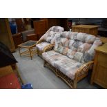 A modern cane conservatory suite comprising settee , chair and glass topped coffee table