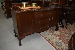 An early to mid 20th Century mahogany sideboard, matched with lot 602, central bow front three