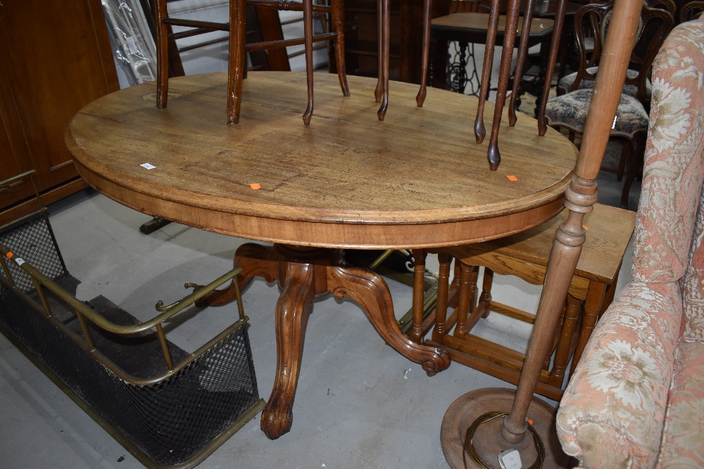 A Victorian bleached mahogany oval top dining table on overstained quadruple splay legs