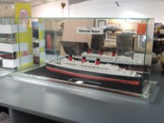 A wooden scratch built model of the RMS Queen Mary, on stand in glass case, total length 73cm
