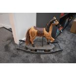 A hand decorated wooden Carousel Horse on wood stand with four metal wheels and rocking base, height