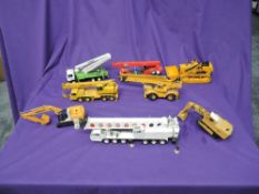 A collection of playworn diecast construction vehicles including BW200 Bomag, NZG Grove Crane in