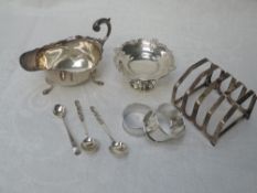 A selection of HM silver including miniature tazza, sauce boat, toast rack, napkin rings, salt spoon