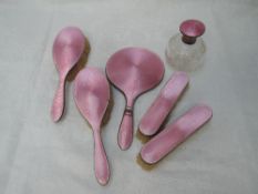 A five piece silver dressing table set and matching perfume bottle all having pink enamel