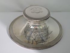 A silver capstan inkwell of traditional circular weighted form, bearing inscription regarding