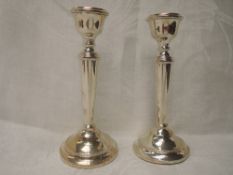 A pair of silver candle sticks of dainty form having tapered columns and weighted bases,