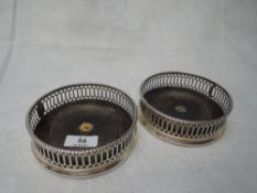 A pair of Georgian silver bottle coasters having gallery borders with rampant lion to cartouches and