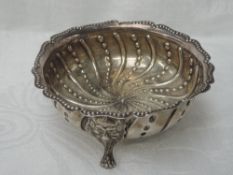 A Victorian silver footed dish having repousse dot and swirl decoration on trefoil mask feet, London