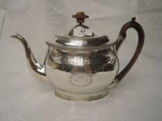 A Georgian silver teapot of oval form having bright cut swag and garland decoration, monogrammed