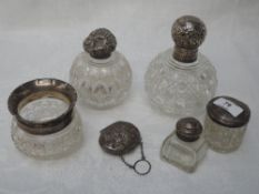 Two cut glass perfume bottles of spherical form having glass stoppers and HM silver lids, three
