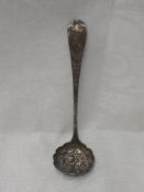 A Georgian Scottish silver sugar sifting spoon/ladle having repousse decoration to frilled bowl