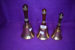 A selection of graduated door or similar brass and wooden handled bells