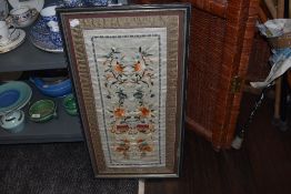 A Framed oriental embroidery using colourful threads, possibly silk or silk blend having a floral