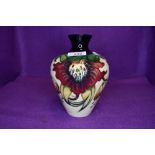 A Moorcroft Anna lily vase having cream ground with red and yellow lily design.