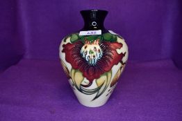 A Moorcroft Anna lily vase having cream ground with red and yellow lily design.