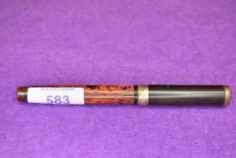 A Mabie Todd Swam leverfill fountain pen with an orange and black patern, the cap top has the same