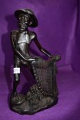 An Indonesian or similar oriental figure of a fisherman with net, well carved and in good condition