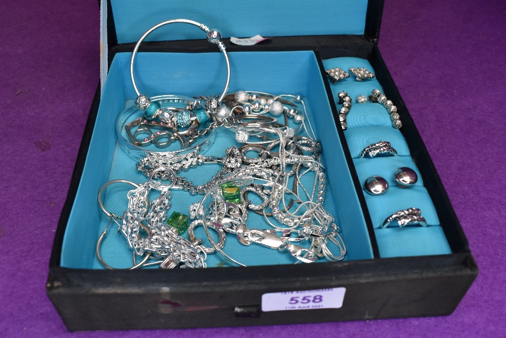 A material jewellery box containing a selection of white metal costume jewellery including