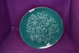 A large Royal Doulton charger having jade green ground with white pattern of ivy,chestnuts and