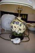 A Moorcroft Hepatica table lamp having cream and blue ground with lilac flowers.