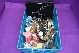 A basket of costume jewellery including bracelets, brooches, rosary beads etc