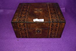 A vintage wooden box having inlaid marquetry detail.