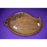 an arts and crafts style cheese board with naturalistic design 34cm long approx