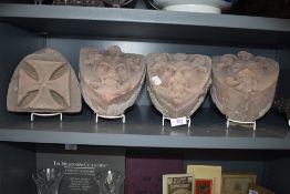 A selection of carved sandstone corbels or gargoyle face masks having been removed from local